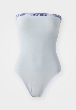 Svetlo modra brezrokavna bodysuit z mehko teksturo in belim pasom, na katerem je modro besedilo "Calvin Klein". Oblikovana je prilegajoče se.