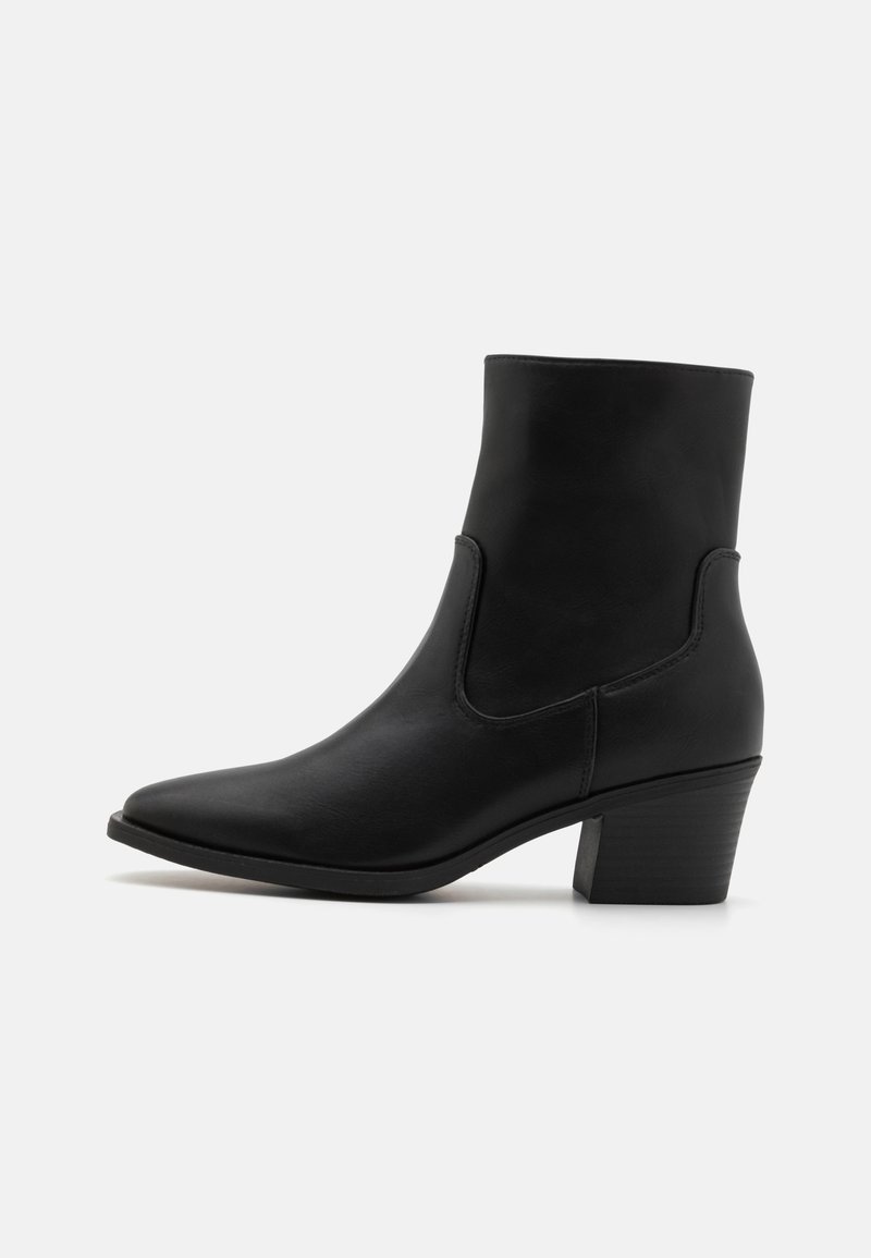 Botte en cuir noire mi-mollet avec bout pointu et talon bloc, vue de profil sur un fond blanc uni.