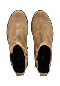 Botas de tobillo de ante marrón con cierre de cremallera, punta redonda y parte superior texturizada. Presentan un forro interior negro y una suela plana.