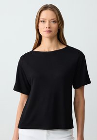 Zwarte T-shirt met korte mouwen en een brede halslijn, gemaakt van zachte stof, met een ontspannen, boxy fit en subtiele stikseldetails.
