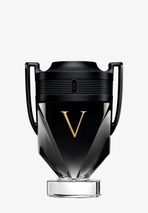 Black and gold trophy-shaped perfume bottle with two handles and a gold letter "V" on the front, resting on a clear round base.