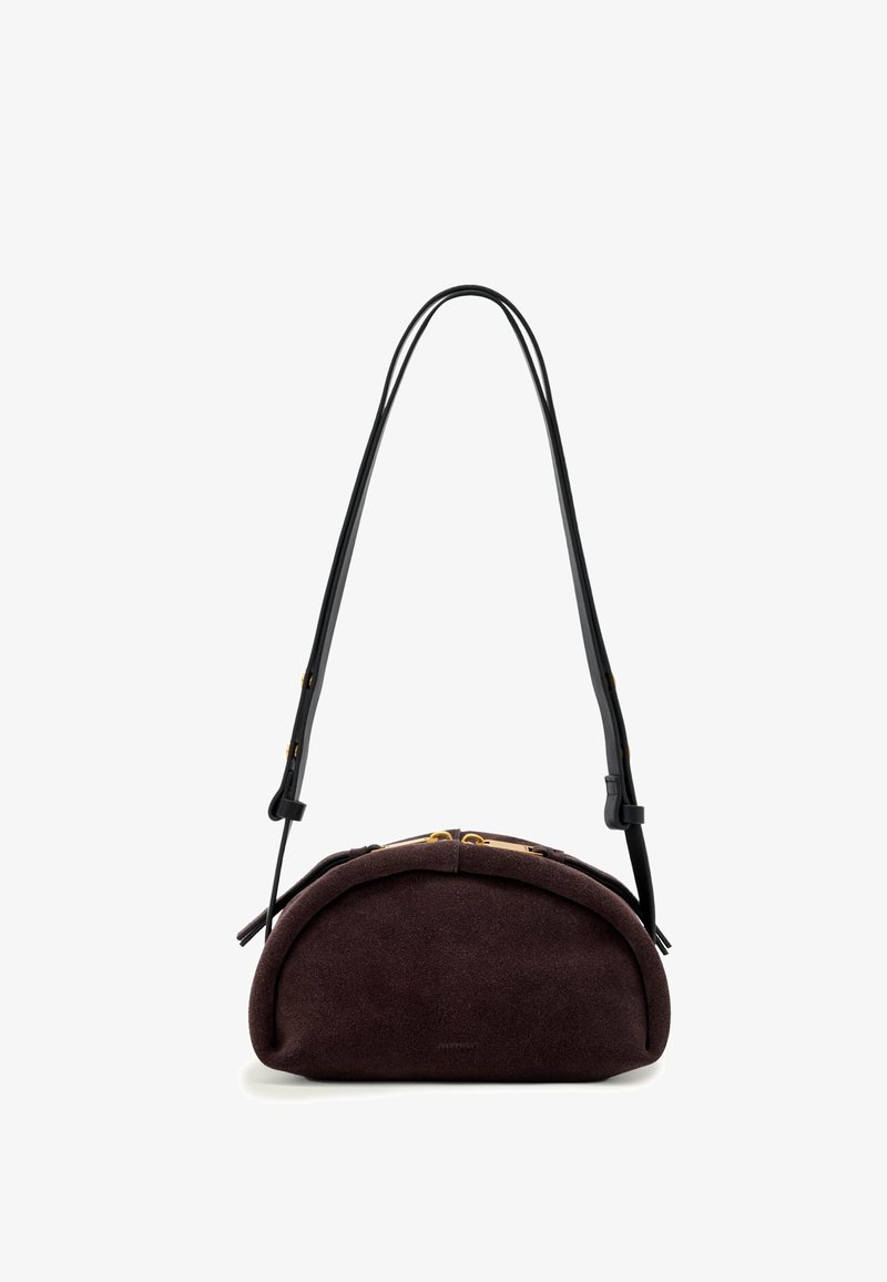 Sac à main en daim brun foncé en forme de croissant avec une longue bandoulière en cuir noir réglable et des détails zippés dorés.