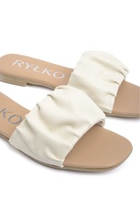 Sandales à glisser en cuir blanc avec dessus froncé, semelle plate et semelle intérieure beige. Présente le logo de la marque imprimé sur la semelle intérieure.