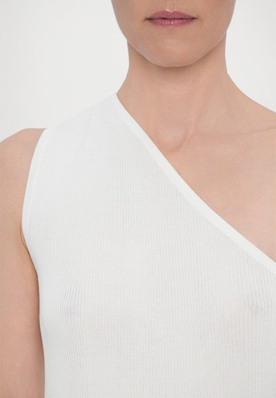 Λευκή, ριγέ, αμάνικη μπλούζα με διαγώνιο λαιμό. Μαλακή υφή, εφαρμοστή σιλουέτα, μινιμαλιστικός σχεδιασμός και χωρίς ορατά σχέδια ή αξεσουάρ.