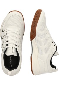 Vita atletiska skor med en mesh-övre, texturerad gummisål, vadderad krage och kontrasterande svarta detaljer på snörning och sidor.