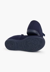 Granatowe buty z materiału, z zaokrąglonym noskiem, elastycznym paskiem oraz teksturowaną gumową podeszwą z kwiatowymi i sercowymi wzorami. Wyprodukowano w Hiszpanii.