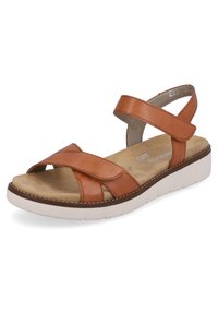 Sandale en cuir marron avec des brides entrecroisées, semelle intérieure rembourrée et semelle en caoutchouc blanc avec un motif texturé.