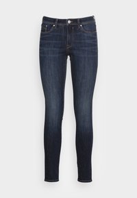 Jeans ajustados de mezclilla azul oscuro; cuentan con cinco bolsillos, presillas para cinturón y un cierre de botón; textura suave con un ligero desvanecimiento en algunas áreas.