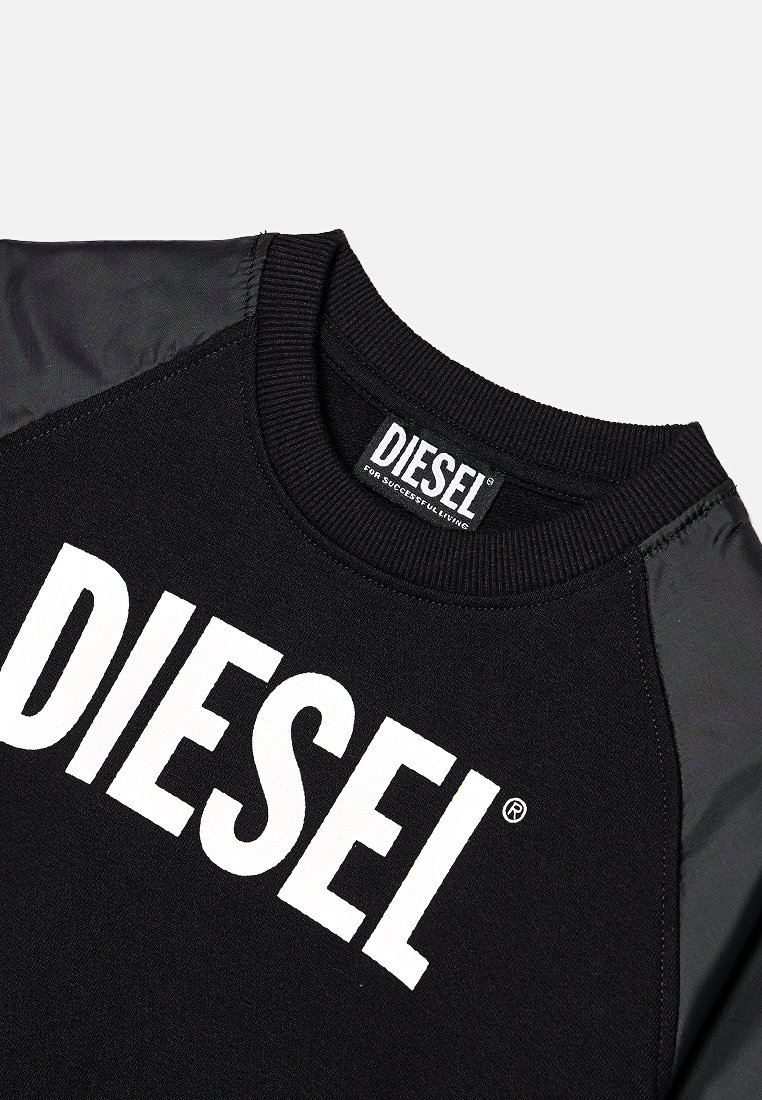 Sweatshirt noir avec un grand logo blanc "DIESEL". Il présente un col rond côtes et un tissu noir contrastant sur les épaules.