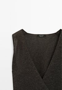 Dark knitted top with a V-neck design. Features subtle texture and a label at the neckline. Material appears soft and lightweight.