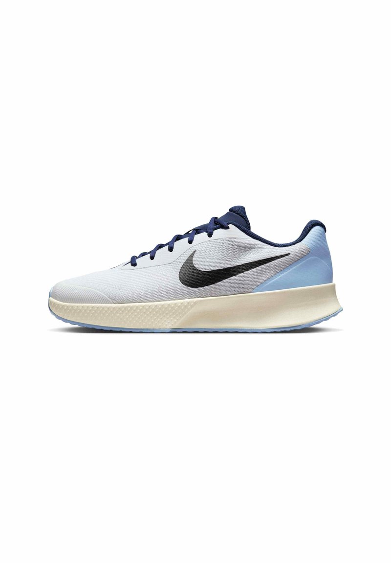 Nike trkaće tenisice s bijelim teksturiranim gornjim dijelom, tamnoplavim akcentima i crnim swoosh logom. Lagani dizajn s podstavljenim izrezom i mekanom petom.