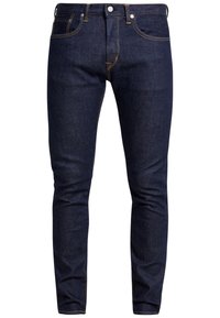 Mörkblå slim-fit denimjeans med orange sömnad, fram- och myntfickor, knäppning och utan synliga slitningar eller dekorationer.