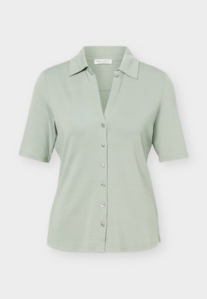 Világoszöld rövid ujjú, gombos ing gallérral, hat gombbal elöl, és egyenes szegéllyel.