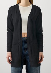 Svart lätt cardigan i ett mjukt tyg, med v-ringning, öppen front, två framfickor och ribbad manschett och nederkant.