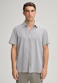 Korte mouw, knoopshirt in lichtgrijs linnen met een subtiele textuur en een puntige kraag. Voorzien van witte knopen en een zijlabel.