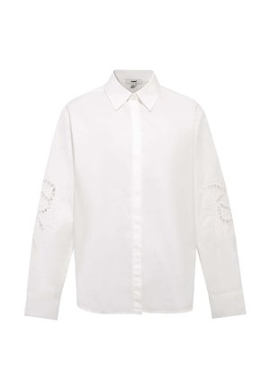 Camicia bianca a maniche lunghe con bottoni, colletto e delicato ricamo in pizzo floreale su entrambe le maniche.