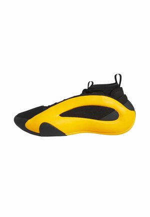 Zapatilla deportiva negra y amarilla con un diseño elegante, que presenta un panel lateral amarillo curvado, parte superior de malla negra y suela de goma.