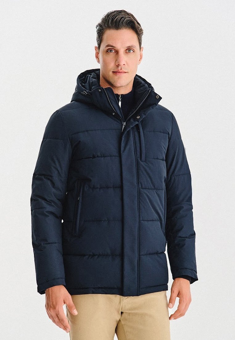 Granatowa kurtka puchowa z kapturem, z pikowanym wzorem, zamek błyskawiczny z przodu oraz dwoma bocznymi kieszeniami. Materiał ma gładką teksturę.