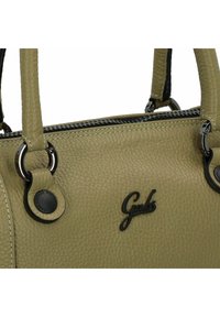 Sac à main en cuir vert olive clair avec une finition texturée, accents de quincaillerie noire, coutures argentées et détail de logo à l'avant.