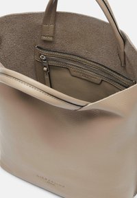 Beige leren tote bag met textuur, open bovenkant en twee handvatten. Binnenin is er een ritsvak en een zachte voering.