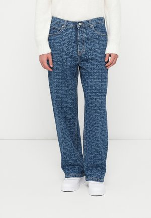 Blue denim jeans featuring an all-over text pattern, loose fit, five-pocket design, and a button closure with a zip fly.