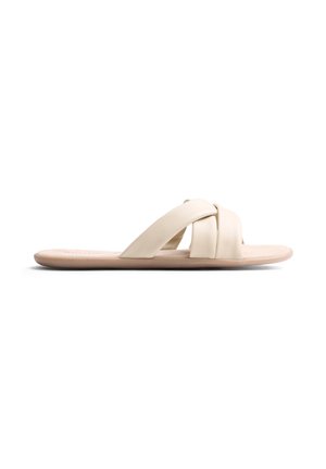 Sandalo beige con ampie fasce imbottite incrociate e suola piatta su sfondo bianco.