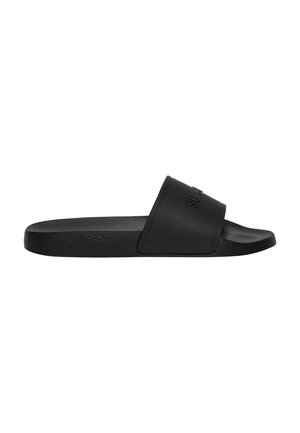 Sandalia tipo slide negra con una tira ancha y suela texturizada, con el nombre de la marca en relieve en la tira.
