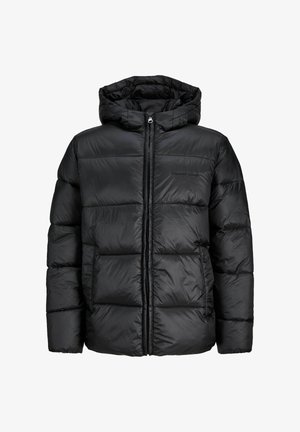 Must musta jope, millel on kapuuts, kapuutsiga punane dressipluus all, laiad sinised teksad ja beežid tenningid valgete detailidega.