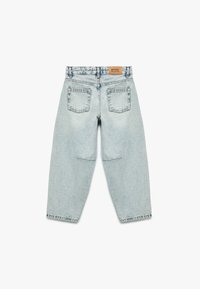 Jeans de mezclilla azul claro con un corte relajado, que cuentan con dos bolsillos traseros y una etiqueta de marca de cuero en la cintura.
