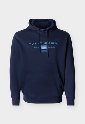 Marineblå hættetrøje med forlomme, snøre og lyseblåt "Tommy Hilfiger American Classics" tekst og logo på brystet.