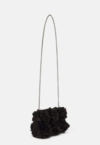 Sac à main noir avec ornements floraux, en tissu, de forme structurée, et une bandoulière chaîne argentée. Accents de fleurs texturées.