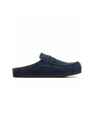 Zapato mule azul marino sin cordones con parte superior de ante y suela de goma marrón, visto desde un lado sobre un fondo blanco.