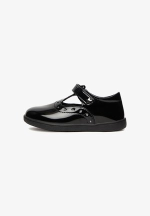 Black patent leather shoe with a T-strap design, secured by a Velcro closure, featuring decorative perforations and a flat sole.