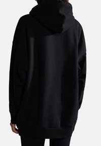 Sudadera negra de gran tamaño con una textura suave, que presenta capucha, hombros caídos, y puños y dobladillo de canalé para un ajuste relajado.
