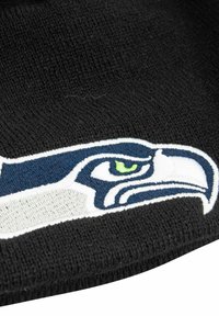 Schwarze Strickmütze mit einem gestickten Logo der Seattle Seahawks in Grün, Marineblau und Weiß. Die Textur ist weich und hat einen gerippten Saum.