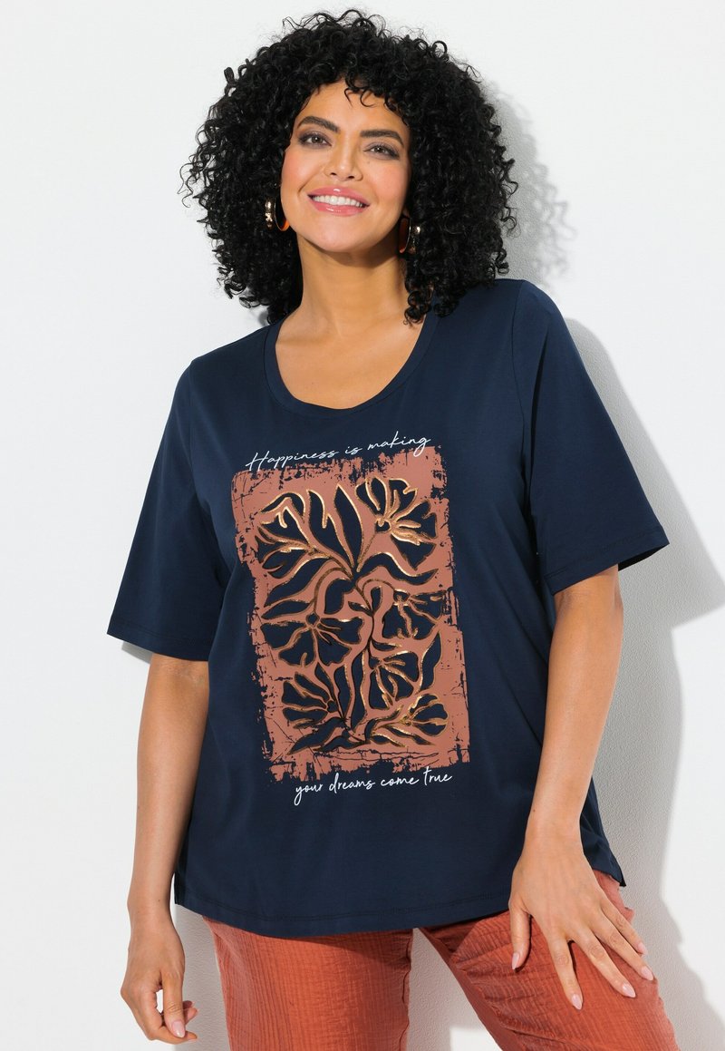 Camiseta de manga corta azul marino con un estampado gráfico floral marrón y texto blanco con frases. Tejido suave, corte relajado.