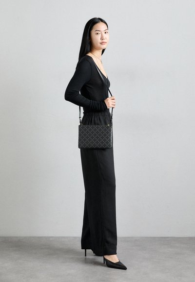Sac crossbody noir avec motif en diamant, forme rectangulaire, bandoulière réglable et accessoires en métal doré. Matériau léger.