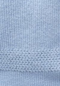 helehall sinine kootud kangas, mille alumises osas on tekstuuriga muster ja ülalpool siledad soonilised osad. Pehme, karvane tekstuur kogu kangal.