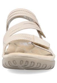 Sandalias beige con tres tiras de tela y cierre de gancho y bucle. Plantilla suave y suela de goma texturizada para facilitar el agarre.