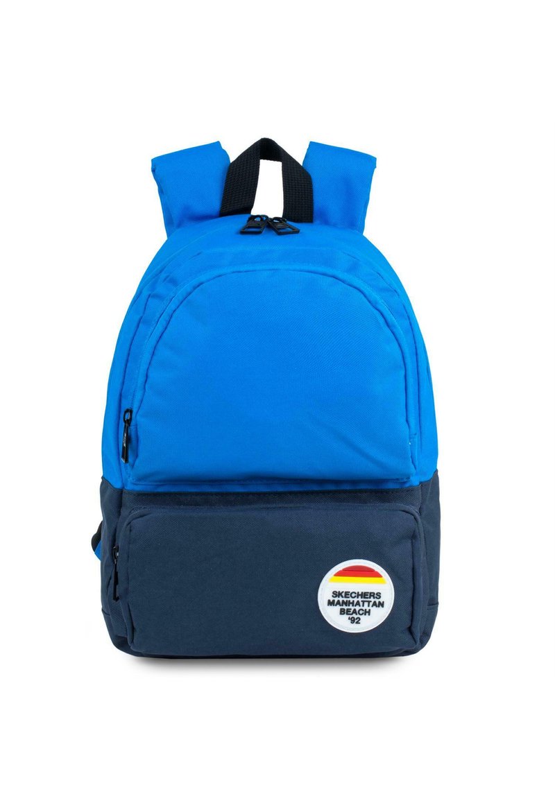 Mochila azul con un bolsillo frontal con cremallera, tirantes negros y un parche de logo con rayas rojas, amarillas y naranjas. El material parece duradero.
