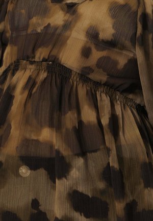 Blouse aux motifs abstraits marron et noir ; tissu léger et transparent avec texture plissée et détail de taille élastique.