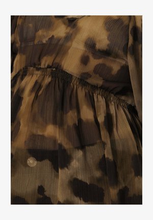 Blouse aux motifs abstraits marron et noir ; tissu léger et transparent avec texture plissée et détail de taille élastique.