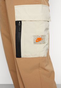 Nike Sportswear PANT - Cargo trousers - driftwood/rattan/safety orange