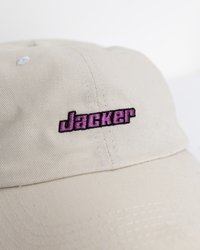 Vaalea läppäpeittynyt puuvillalippalakki, jossa on kaareva lippa. Edessä on musta ja vaaleanpunainen brodeerattu "Jacker"-logo.