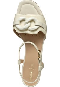Off-white sandal med en bred rem med en dekorativ kedjelänk, ankelrem med ett gyllene spänne och en vadderad sula.