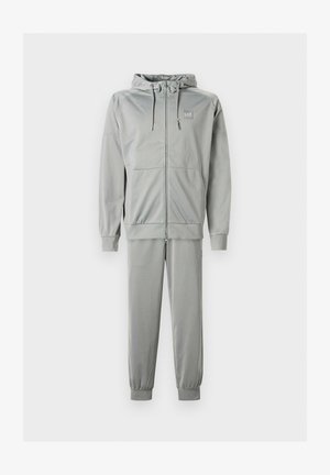 Tuta sportiva grigio chiaro composta da felpa con cappuccio con zip e coulisse regolabili e pantaloni abbinati a gamba affusolata con polsini elastici.