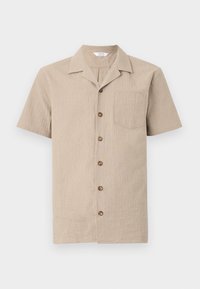 Camisa de manga corta beige en un tejido texturizado, con cuello, un bolsillo en el pecho y botones marrones en el frontal.