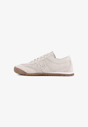 Zapatilla deportiva beige informal con paneles de malla y ante, logotipo redondo en el lateral, cierre de cordones y suela de goma marrón.