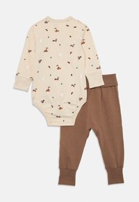 Beige long-sleeve baby bodysuit with woodland animal and leaf prints paired with solid brown ribbed cuff pants.