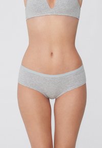 Šedá bavlněná souprava spodního prádla s měkkým pásem. Podprsenka má design s V-výstřihem, zatímco kalhotky jsou ve stylu boyshort s plochým páskem.